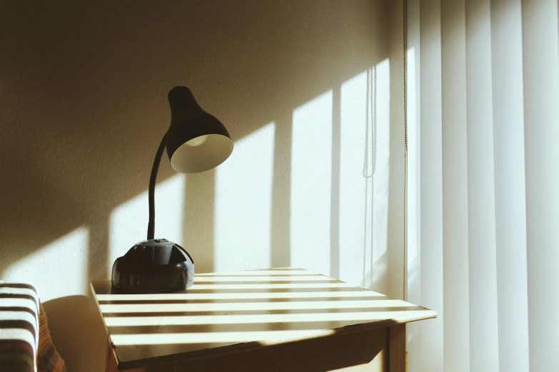 lamp sitting on top of a table in front of a window