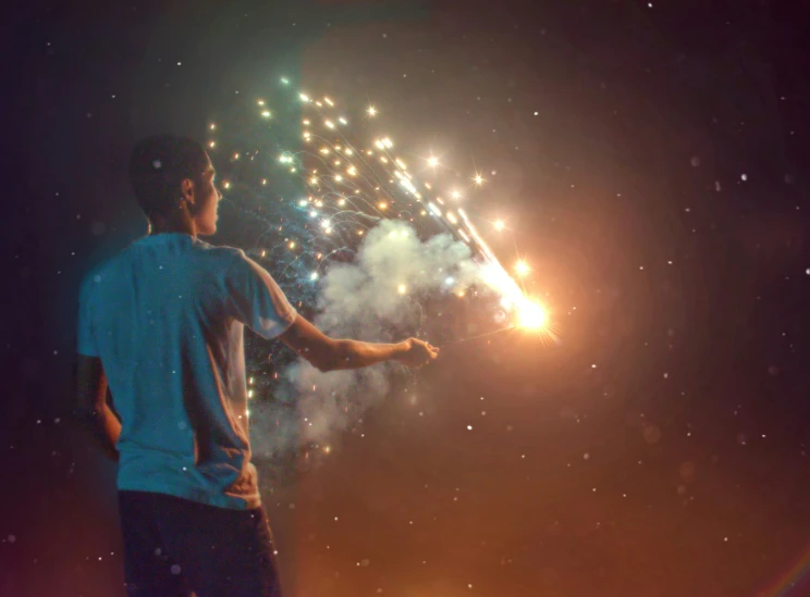 a man holding a fireworks that is floating off a beach