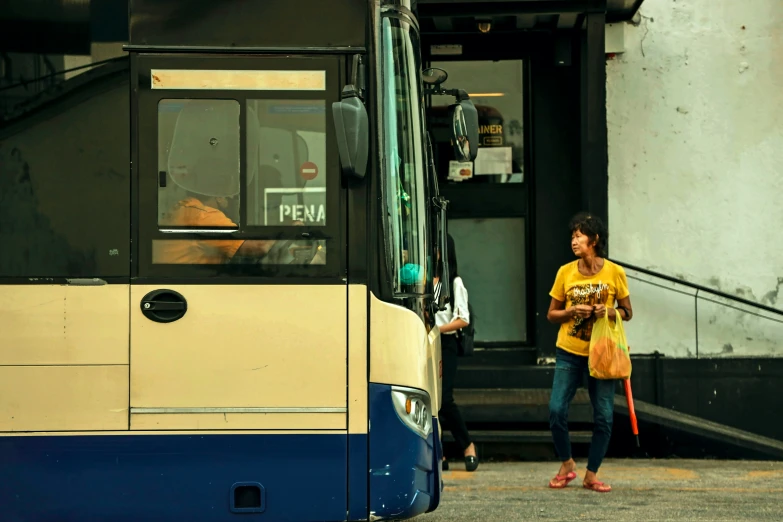 the man walks towards the bus as it is about to make her way