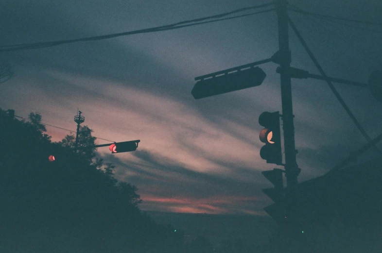 a stop light and some traffic signal lights at night