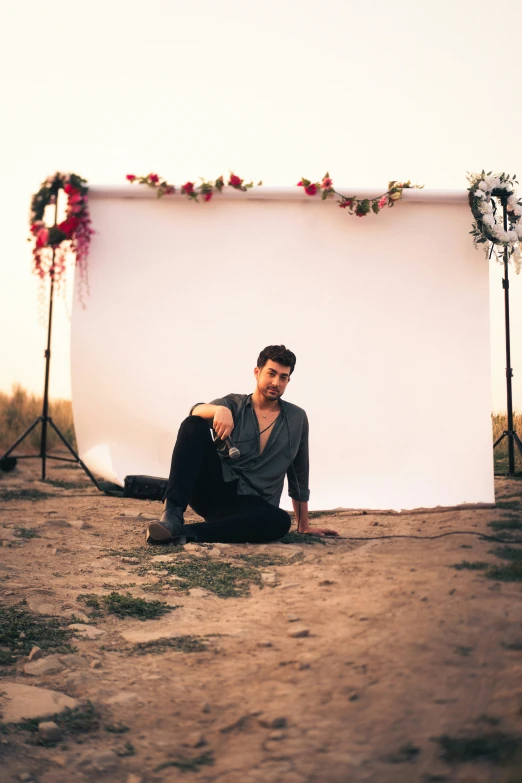 a man sitting in front of an empty backdrop