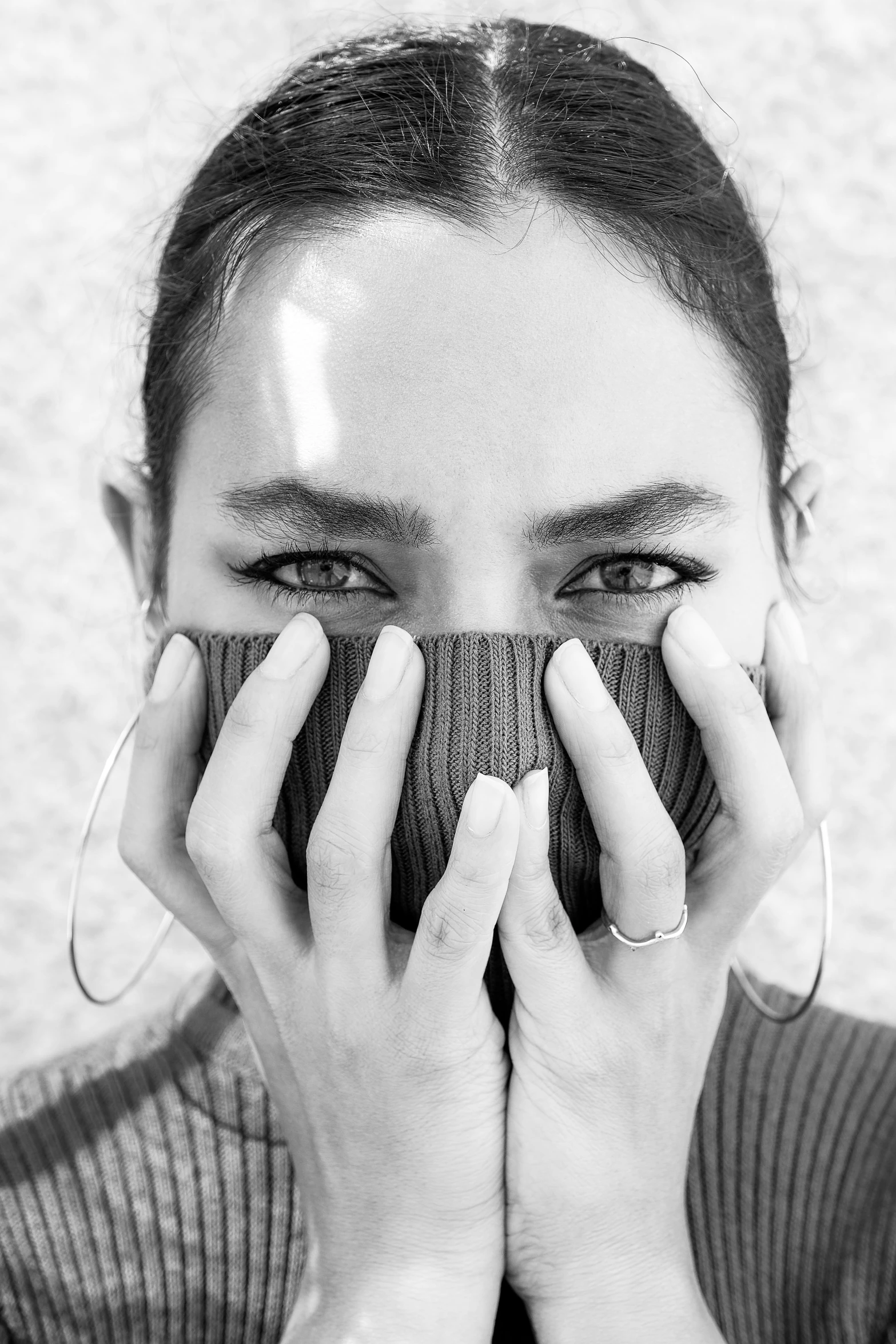 black and white po of a woman covering her face with her hands