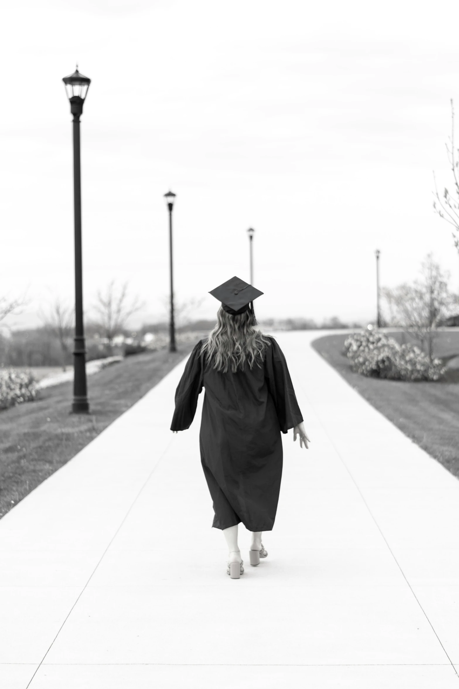 a black and white po of a person wearing a graduation gown