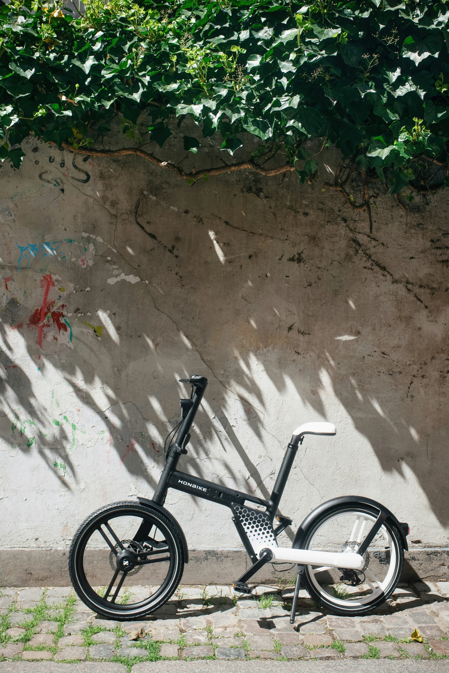 bicycle leaning up against a wall with graffiti