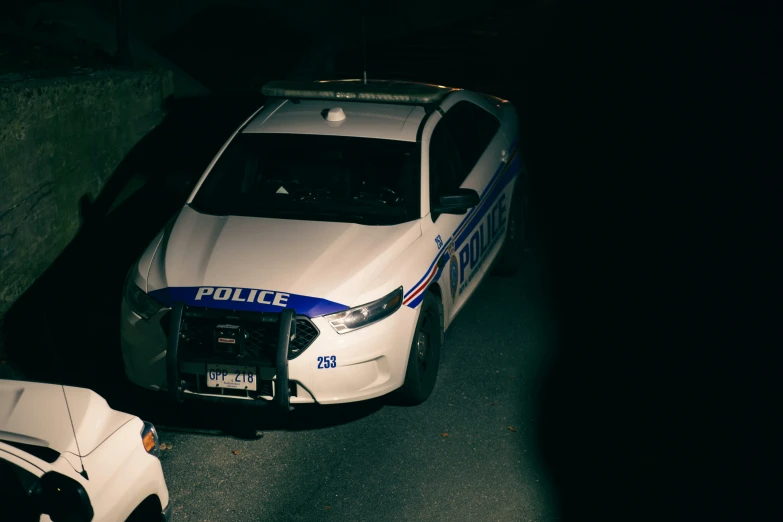 two police cars parked on the side of a road at night