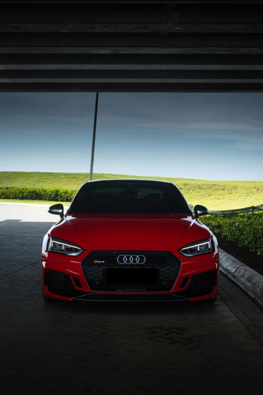 an audi rs is parked under an overpass