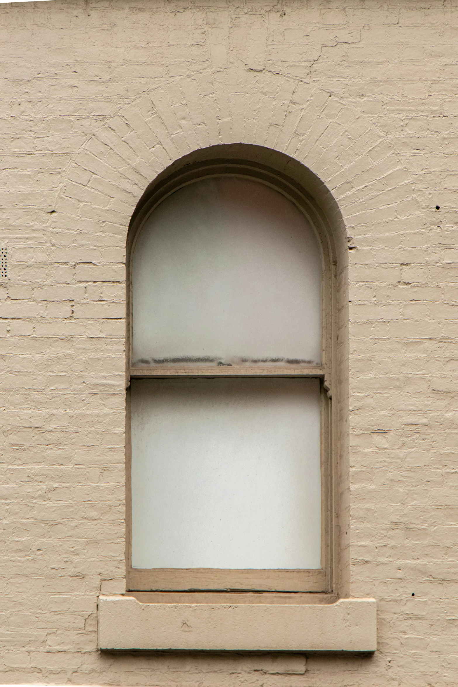 a window with a stone surround is seen from below