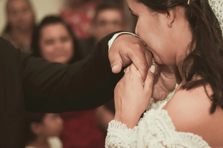 a couple standing close together and putting on their wedding rings