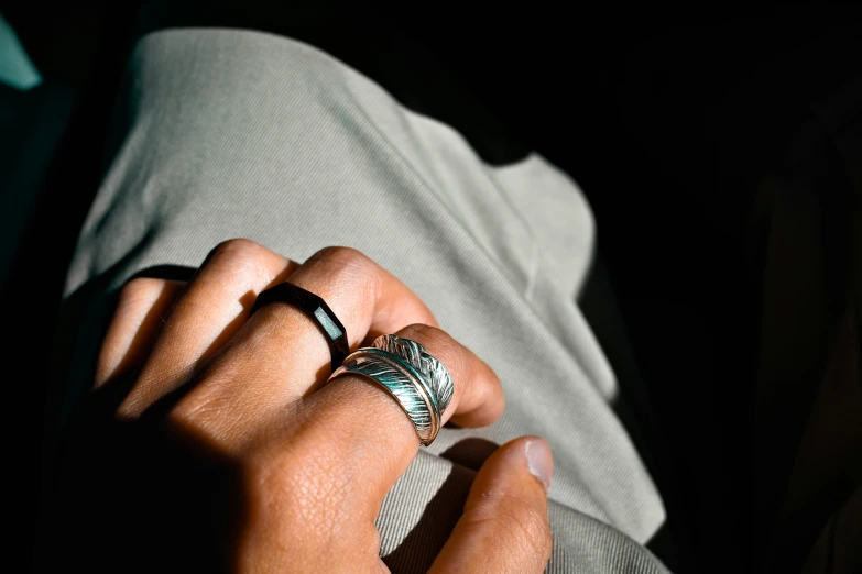 a person with their hand on his hip and wearing two rings,