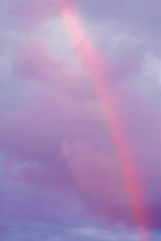 a colorful rainbow is coming out over a cloudy sky