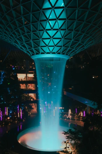 a fountain in the middle of a building at night