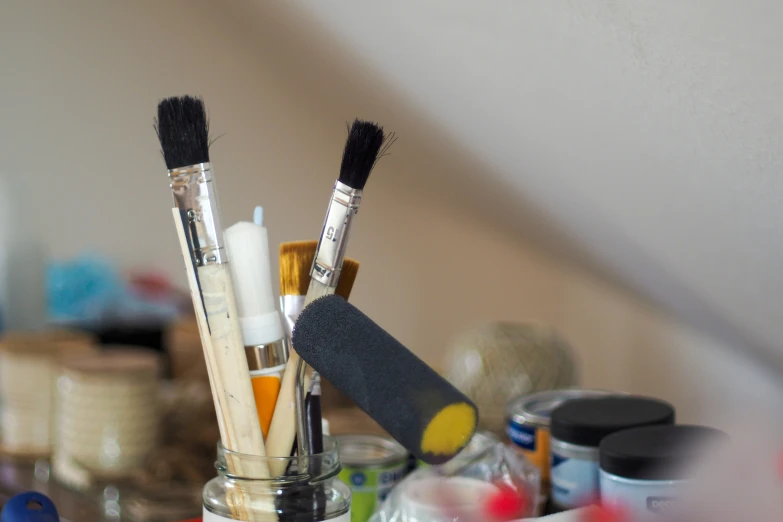 makeup brushes and other cosmetics are in a jar