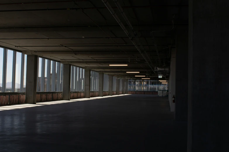 a long walkway between large windows looking outside