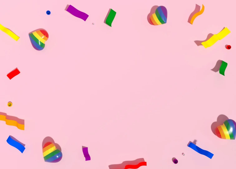 colorful confetti arranged in a circle on a pink surface