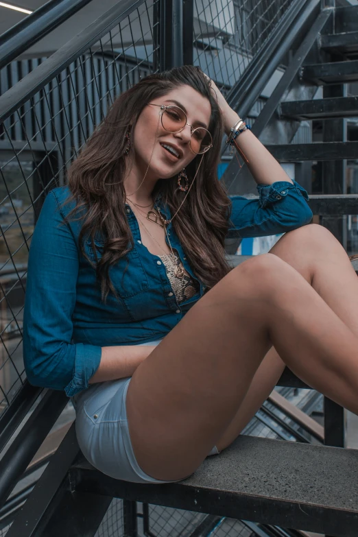 a woman in shorts sitting down on the stairs