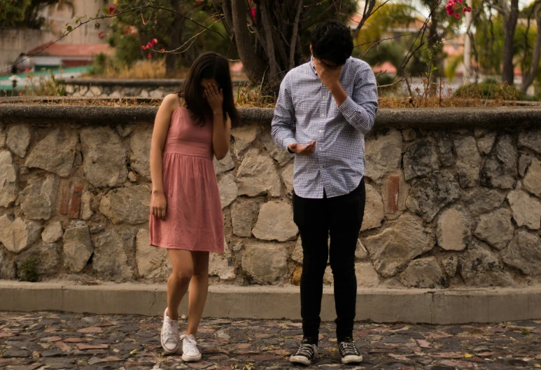 man standing next to a woman while talking on her cell phone