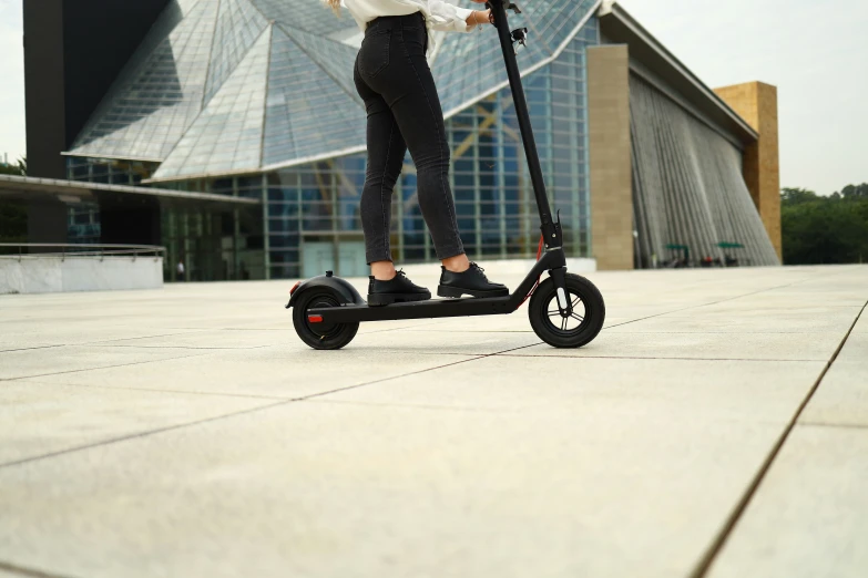 a woman is using her scooter while wearing a shirt and jeans