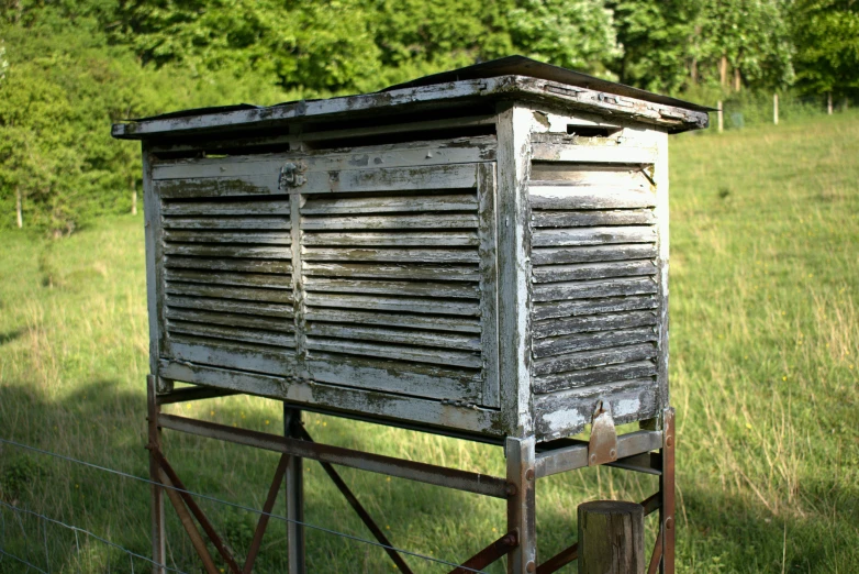 an old outhouse sitting in the middle of a field