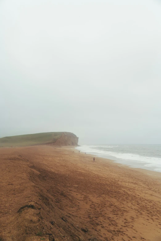 a very wide sandy beach next to the ocean