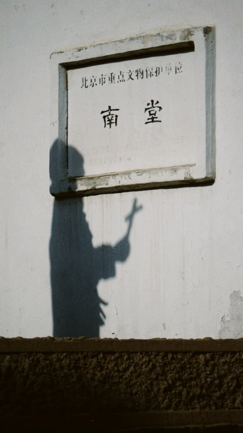 a shadow on the wall of a man holding a gun