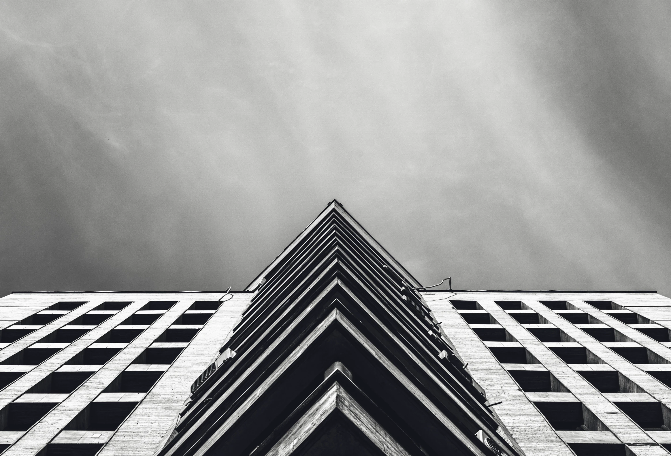 black and white pograph of building under gray sky