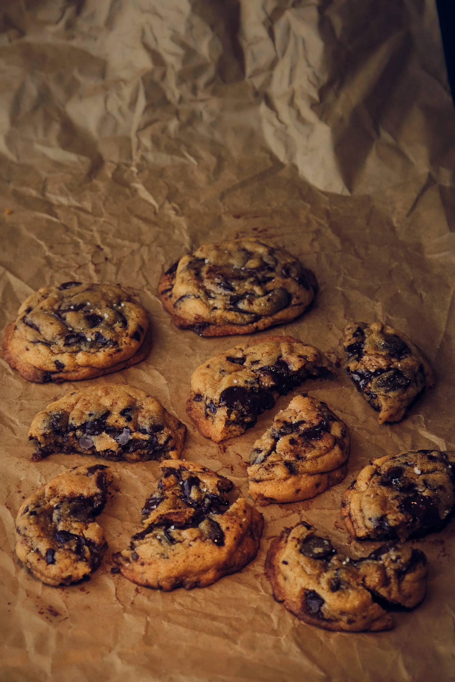 cookies with chocolate chips on top sit on a piece of wax paper