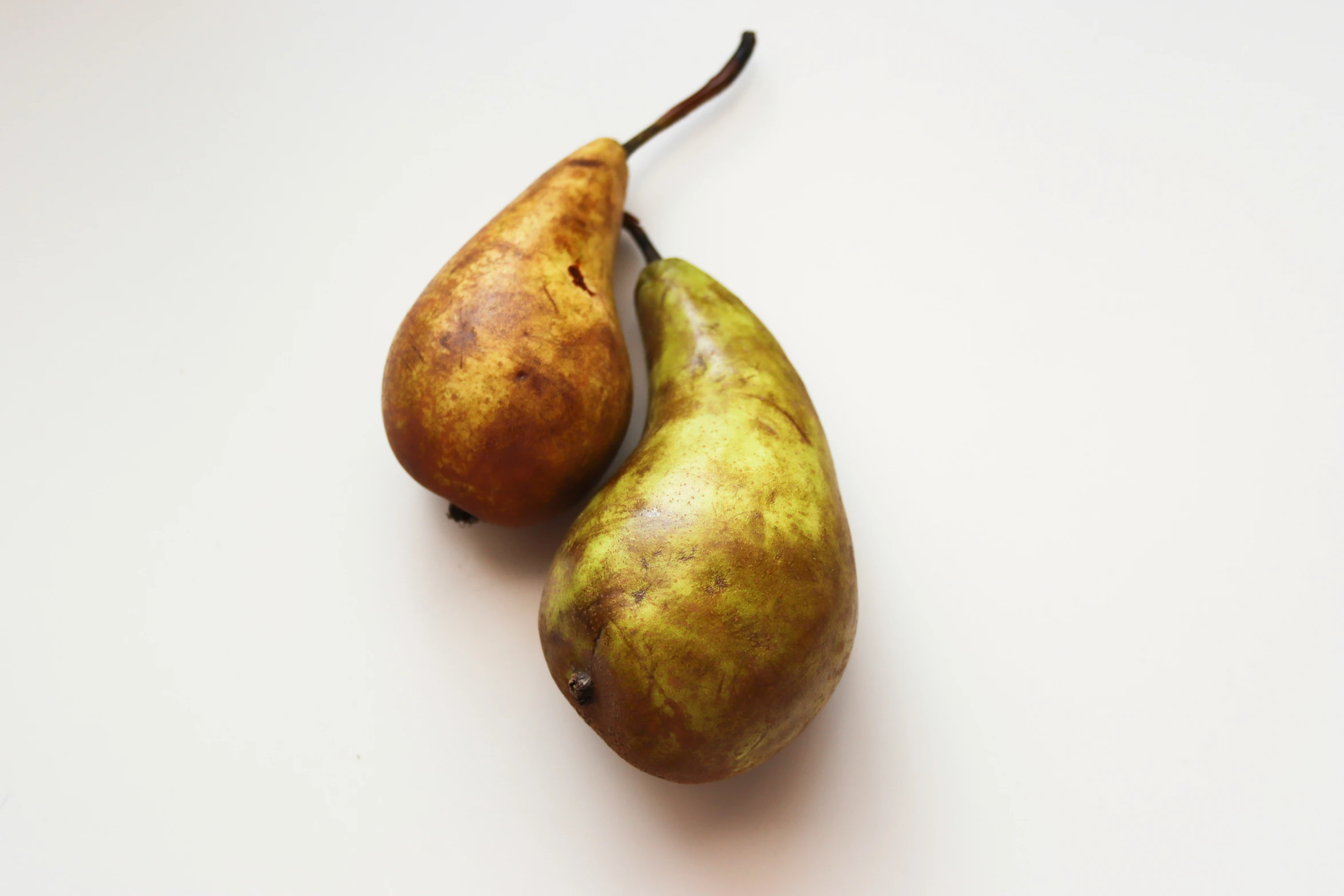 two pears sitting on a white table top