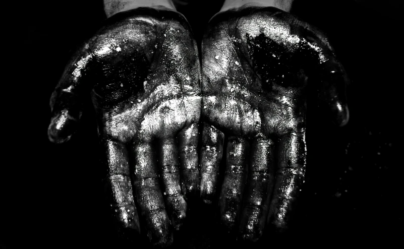 a person is holding up their hands with black and white paint