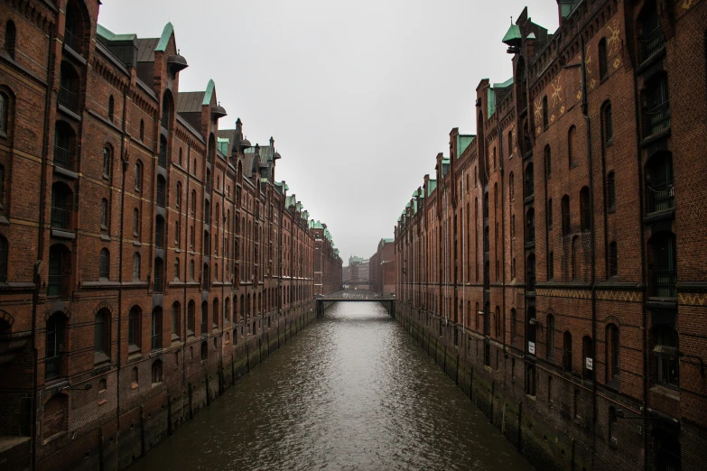 a canal that runs between some brown brick buildings