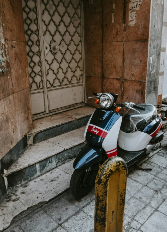 the motor scooter has been abandoned in the back alley