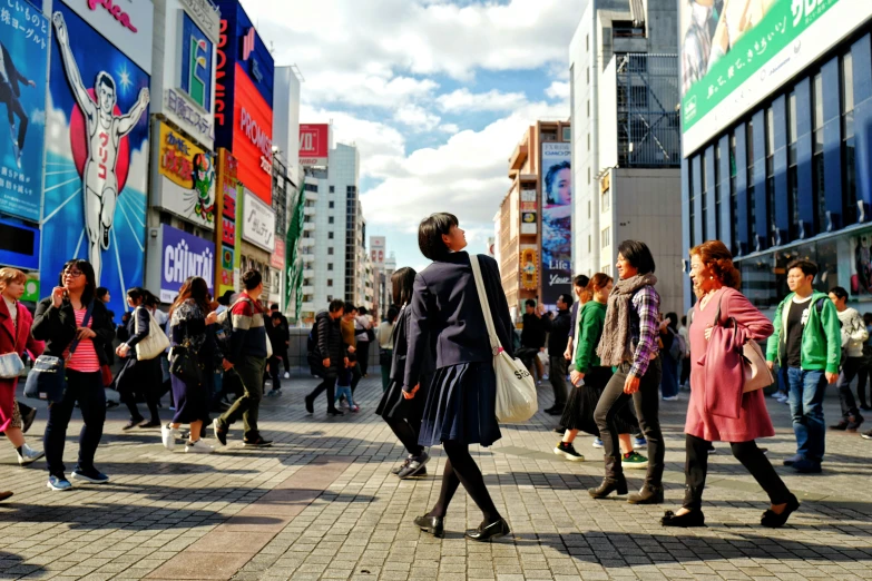 people walk through a plaza on a sunny day