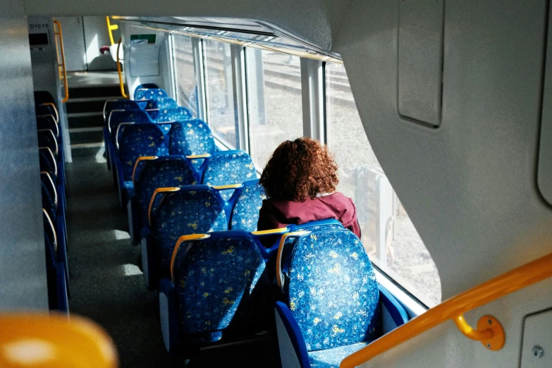 a young child riding on a bus with blue seats