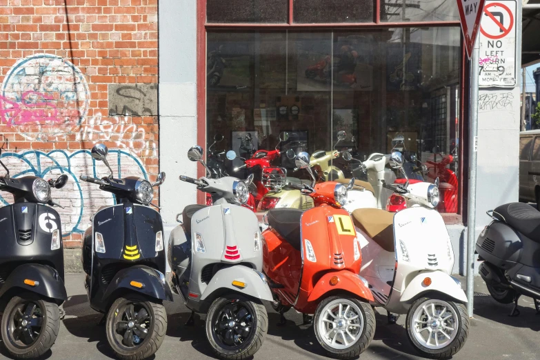 multiple mopeds parked on a side walk near a store