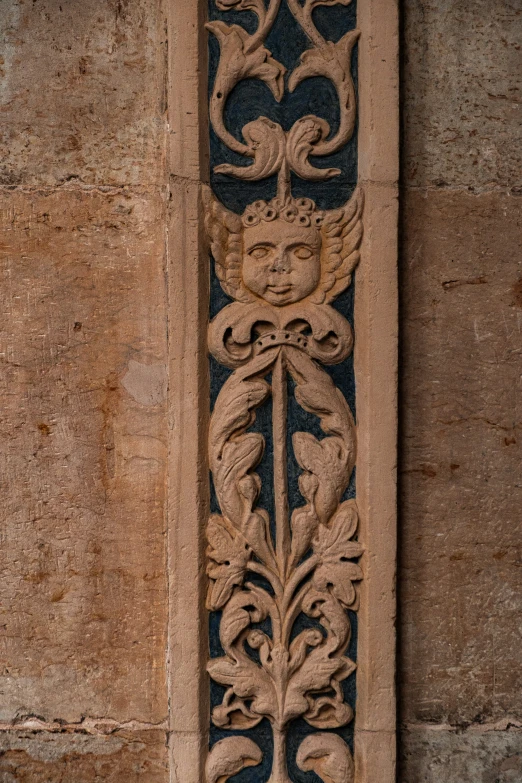 an intricate carving is mounted to the side of a building