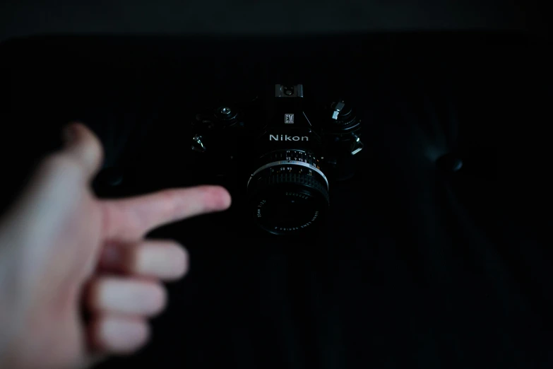 a close up of someone pointing to an analog camera