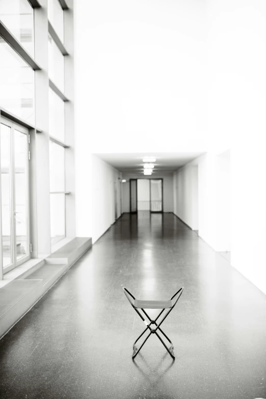 a black and white po of a chair in a room with windows