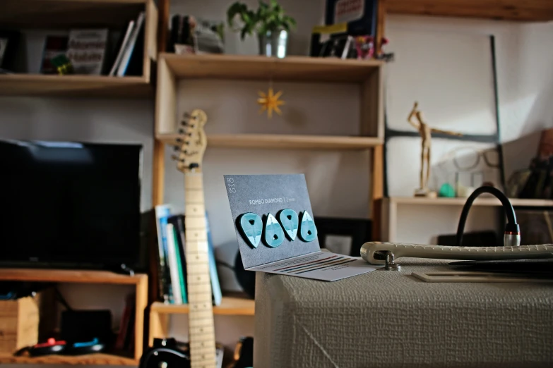 an old suitcase, guitar and book case in a cluttered living room