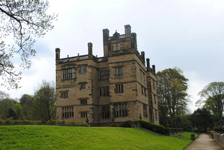 the front of an old brick building on a grass field