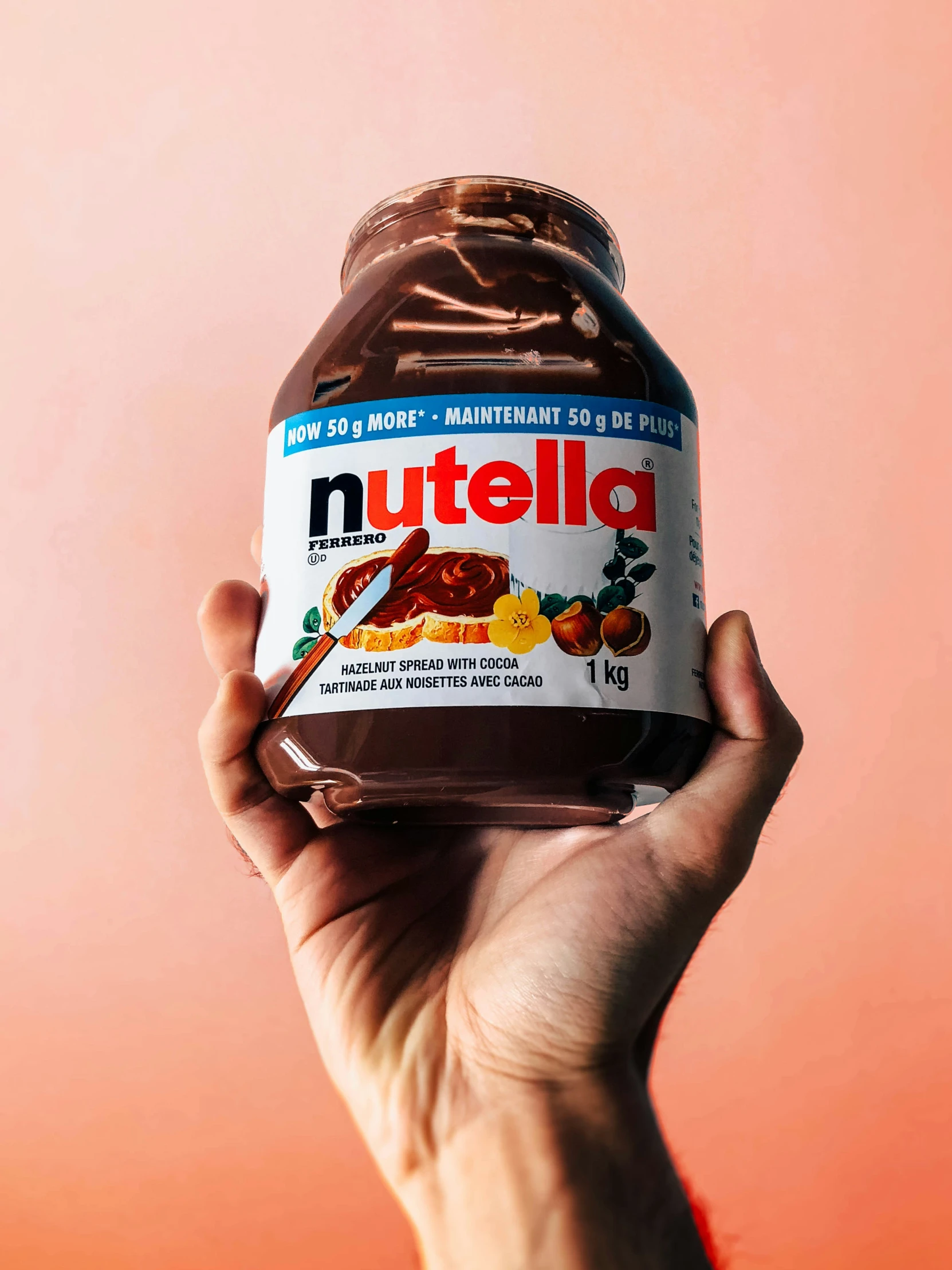 person holding up an opened nutella jar