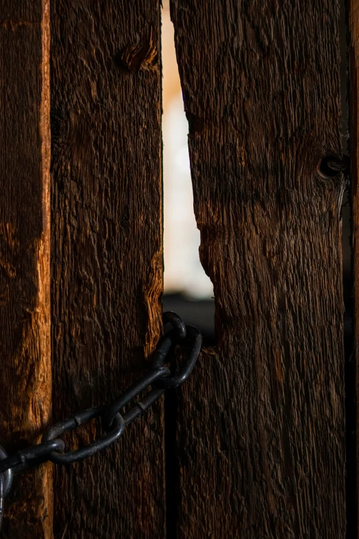 a chain hanging from an open wooden door