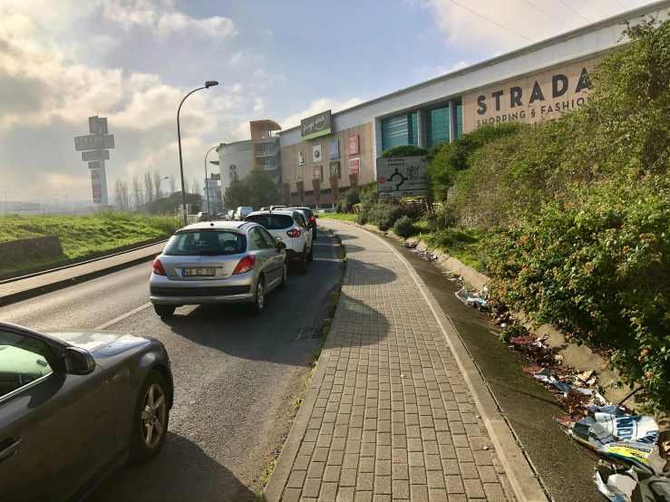 a long line of cars that are sitting in front of a building