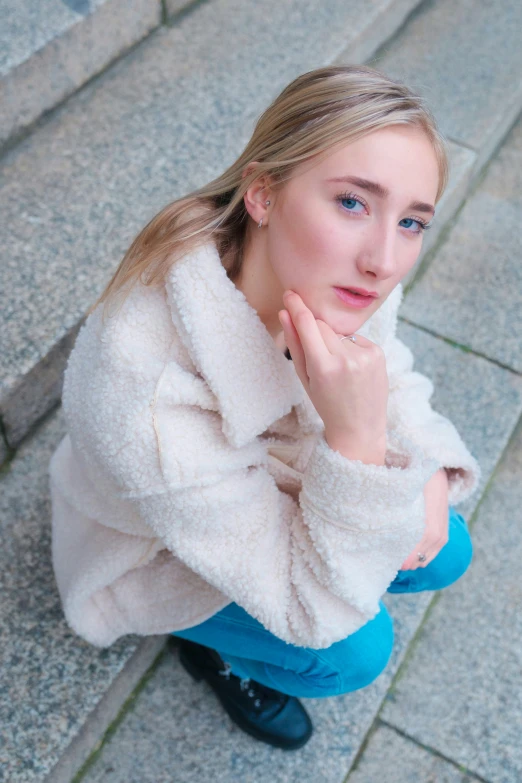 a young woman sitting on stairs next to cement steps