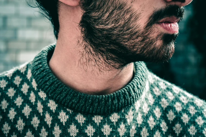 a bearded man looks towards the side