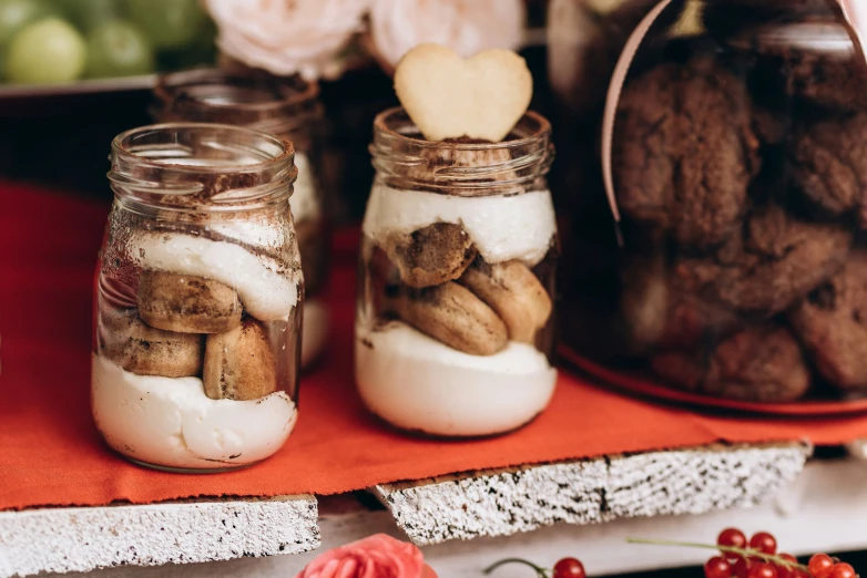 a variety of nuts and cookies sit in mason jars