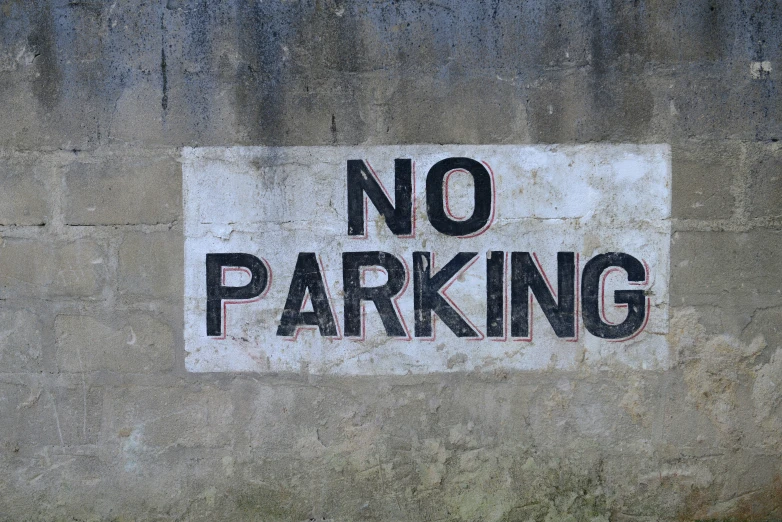 a white and black sign sitting on the side of a building