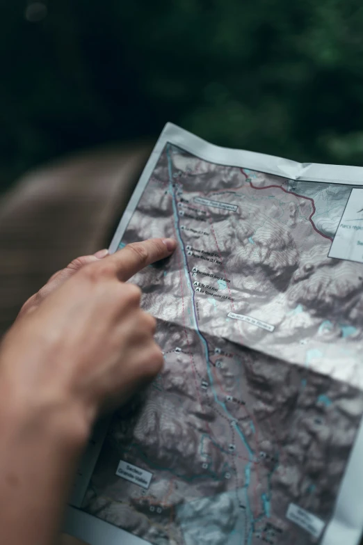 a person's hand on top of a map