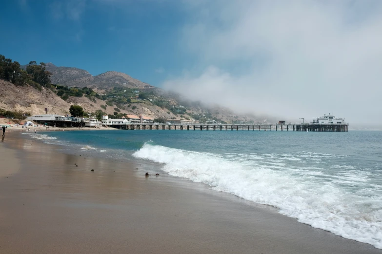 a view of a long pier at the beach