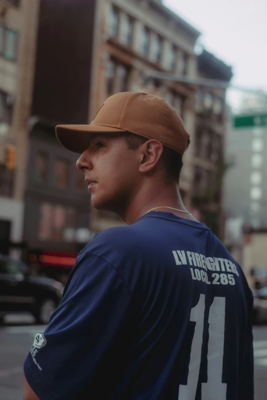 a man is wearing a brown cap standing near the street