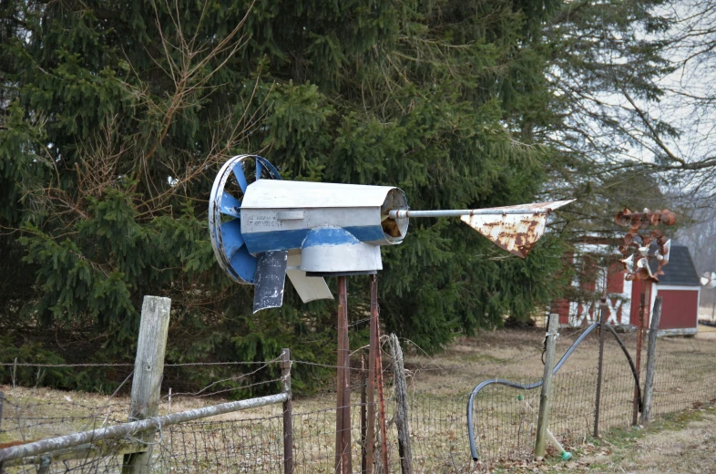 a birdhouse sitting on top of metal posts by trees