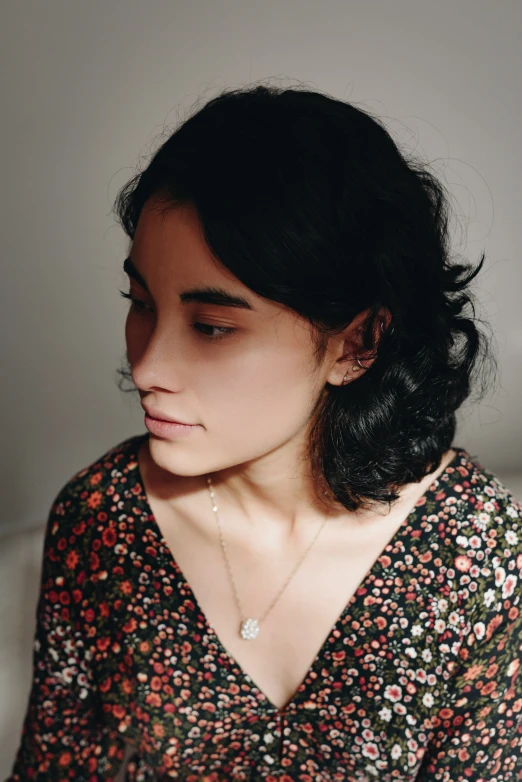 a close up view of a person with short hair wearing a flowered dress